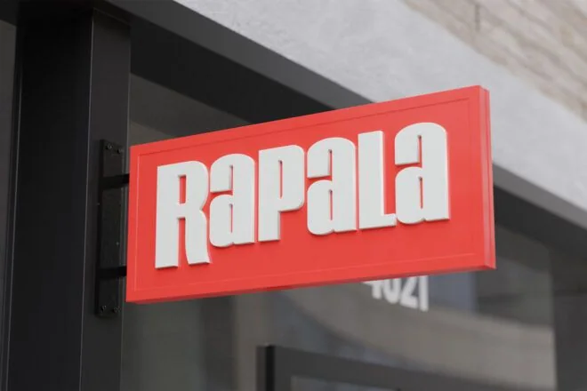 Red projecting blade sign mounted perpendicular to a storefront