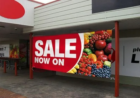 Red promotional sale banner displayed at the front of a retail store